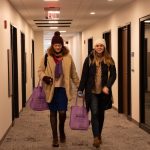 Two students walking in HSSC hallway